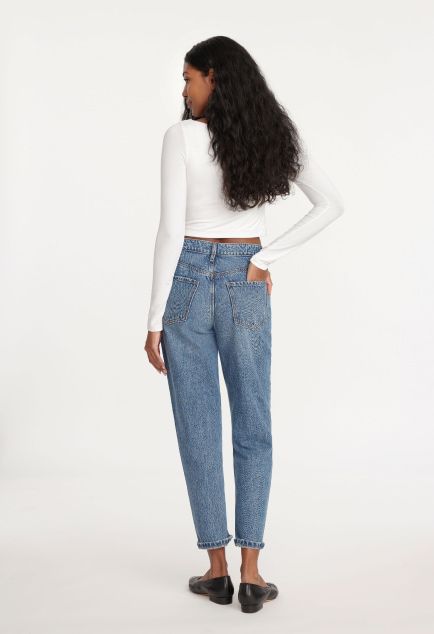 Model is wearing a white T-shirt and blue high-rise mom jeans.