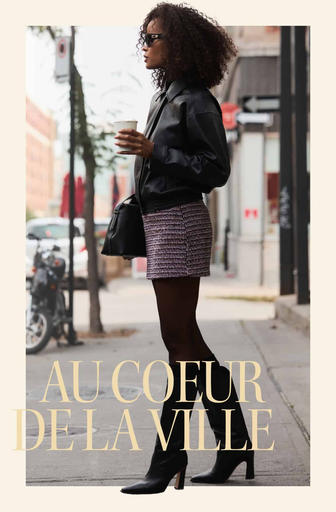 La mannequin porte un blouson en faux cuir noir avec une minijupe en tweed mauve et des collants diaphanes.