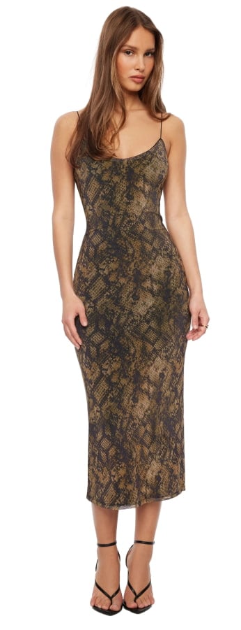 La mannequin porte une robe midi brune à imprimé peau de serpent.