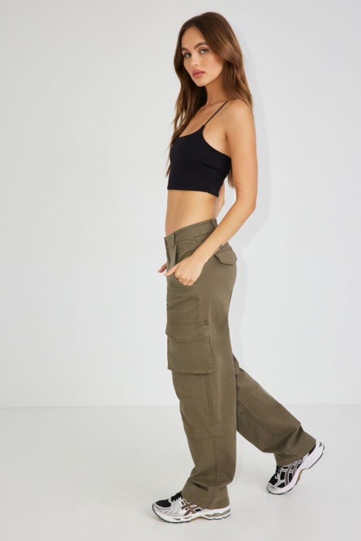 Model wears a black tank top and khaki cargos. 