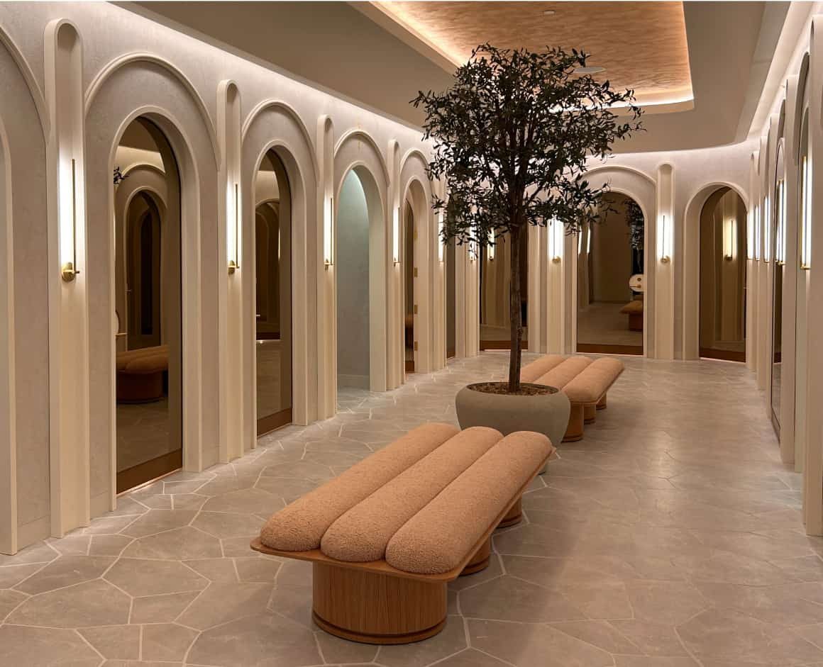 Dynamite fitting rooms with gold doors and off white padded benches.