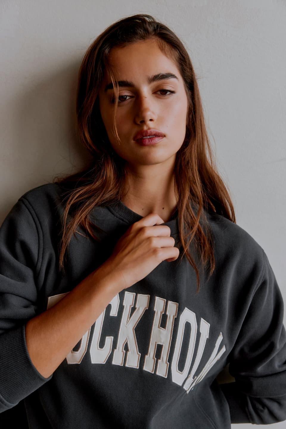 A model wears a grey graphic crew neck.