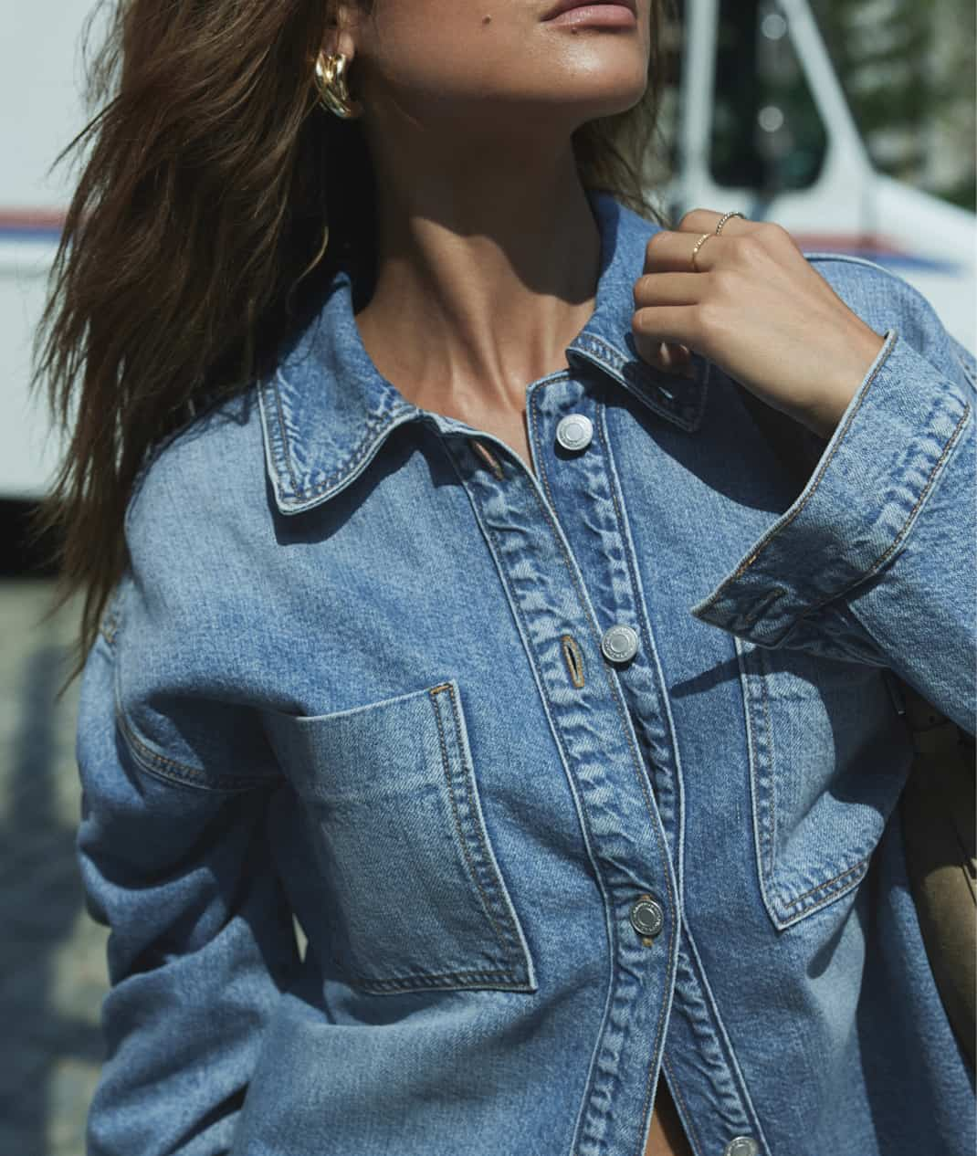 Model is wearing a blue denim shirt.