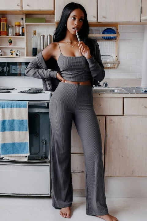 Model wears a matching grey tank top, sweatpants, and sweater.