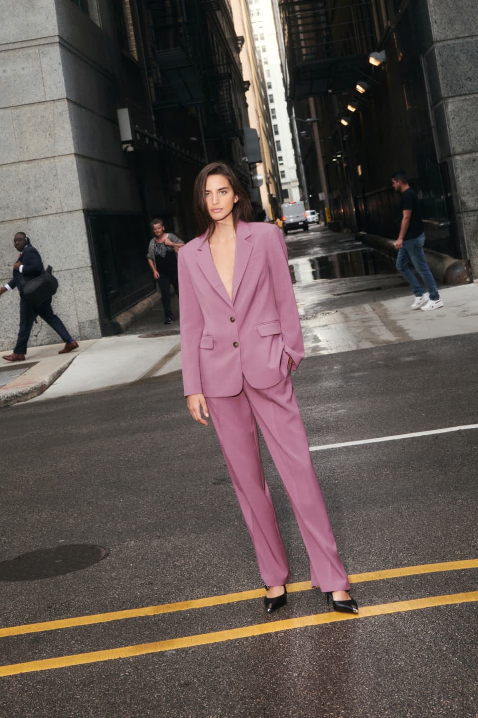 A model wears a fuschia pink straight leg pant with a matching blazer.