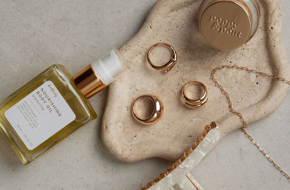 Rings, a hair clip, and other beauty products sit on a tray.