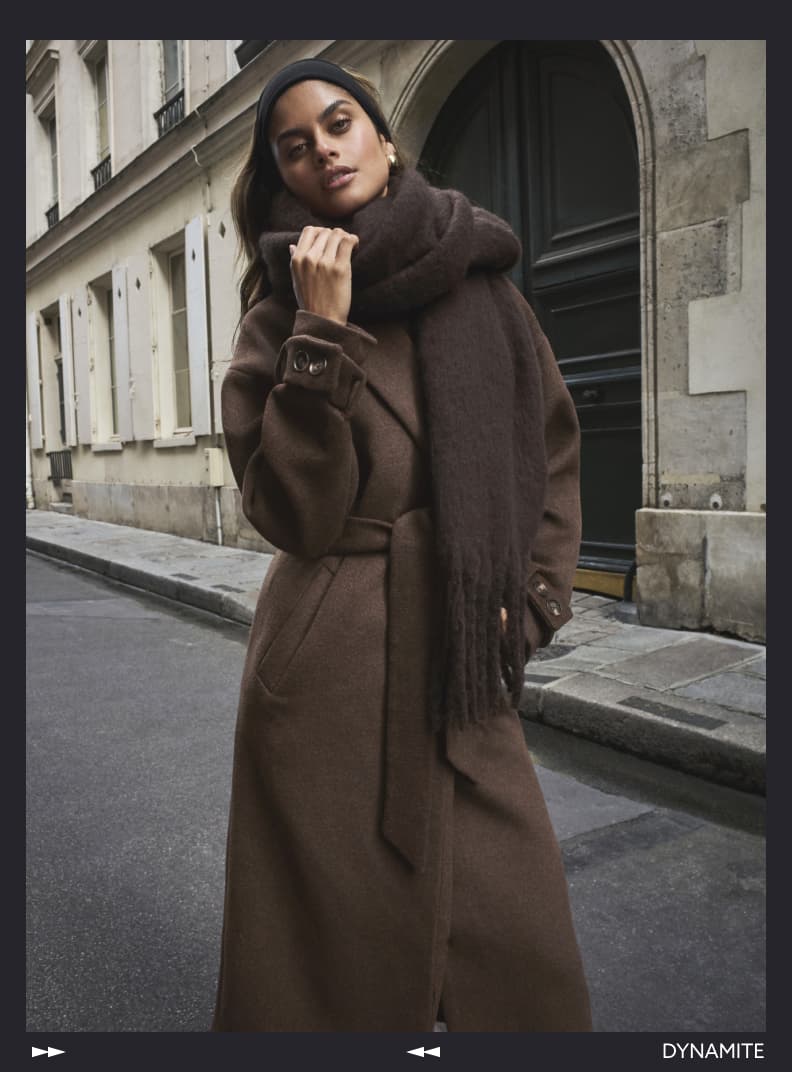 Model is wearing a brown scarf with a brown coat.